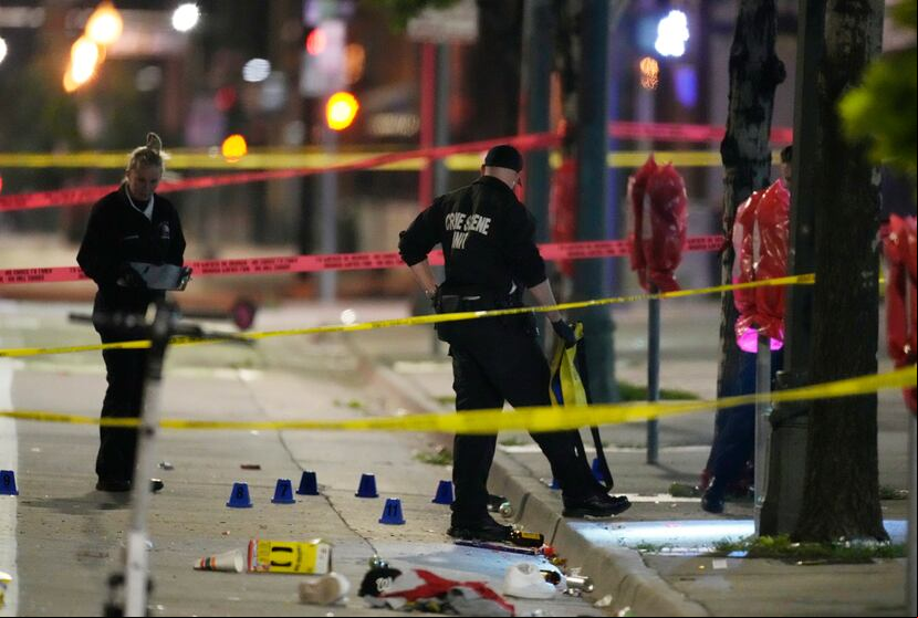 Investigadores del Departamento de Policía de Denver, trabajan en la escena de un tiroteo masivo en Market Street, entre la 20ma y la 21ra avenidas, durante al celebración del título de la NBA de los Nuggets en Denver.