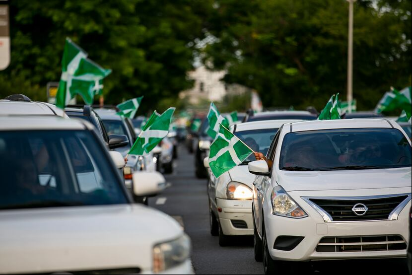 Fila de autos con banderas del PIP que hacen fila para pasar frente a las oficinas centrales de la colectividad en Hato Rey.