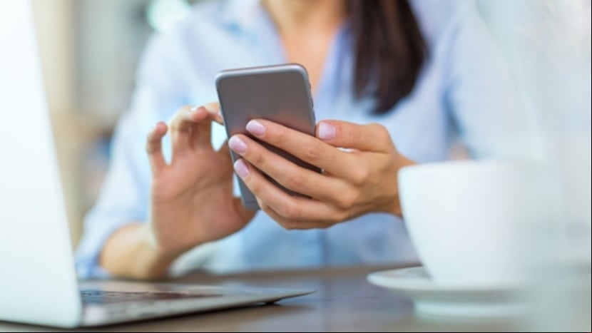 Una mujer sostiene su celular.