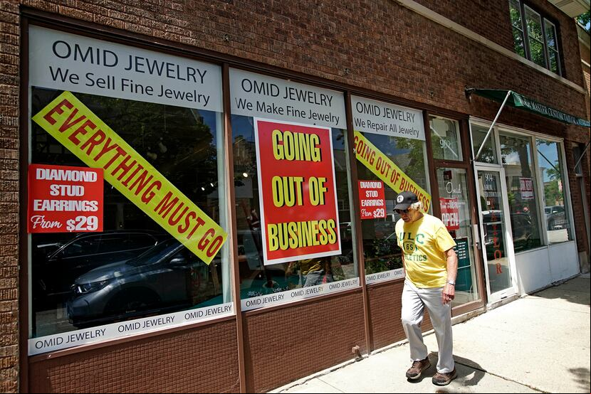 Un hombre pasa por al frente de un comercio que cerró tras la pandemia en Illinois, Estados Unidos.