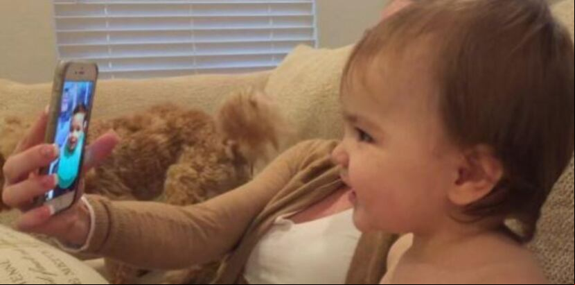 El material audiovisual muestra a uno de los infantes sentado al lado de su madre, quien sujeta un celular donde aparece la imagen del otro bebé.